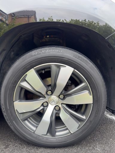 Close-up of a car wheel with a shiny alloy rim and tyre.